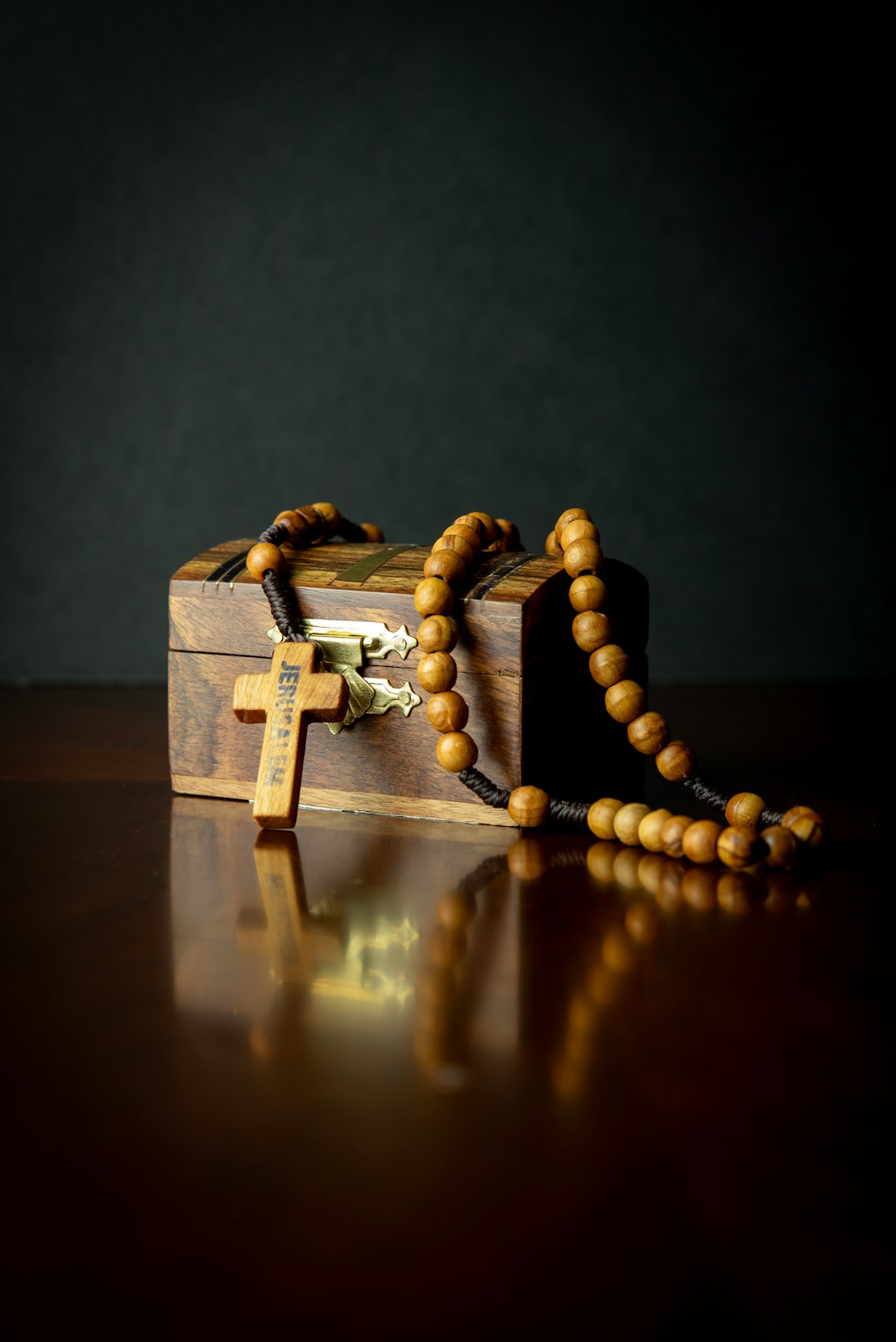 a-wooden-box-with-a-rosary-on-it-imcwbb8-cu