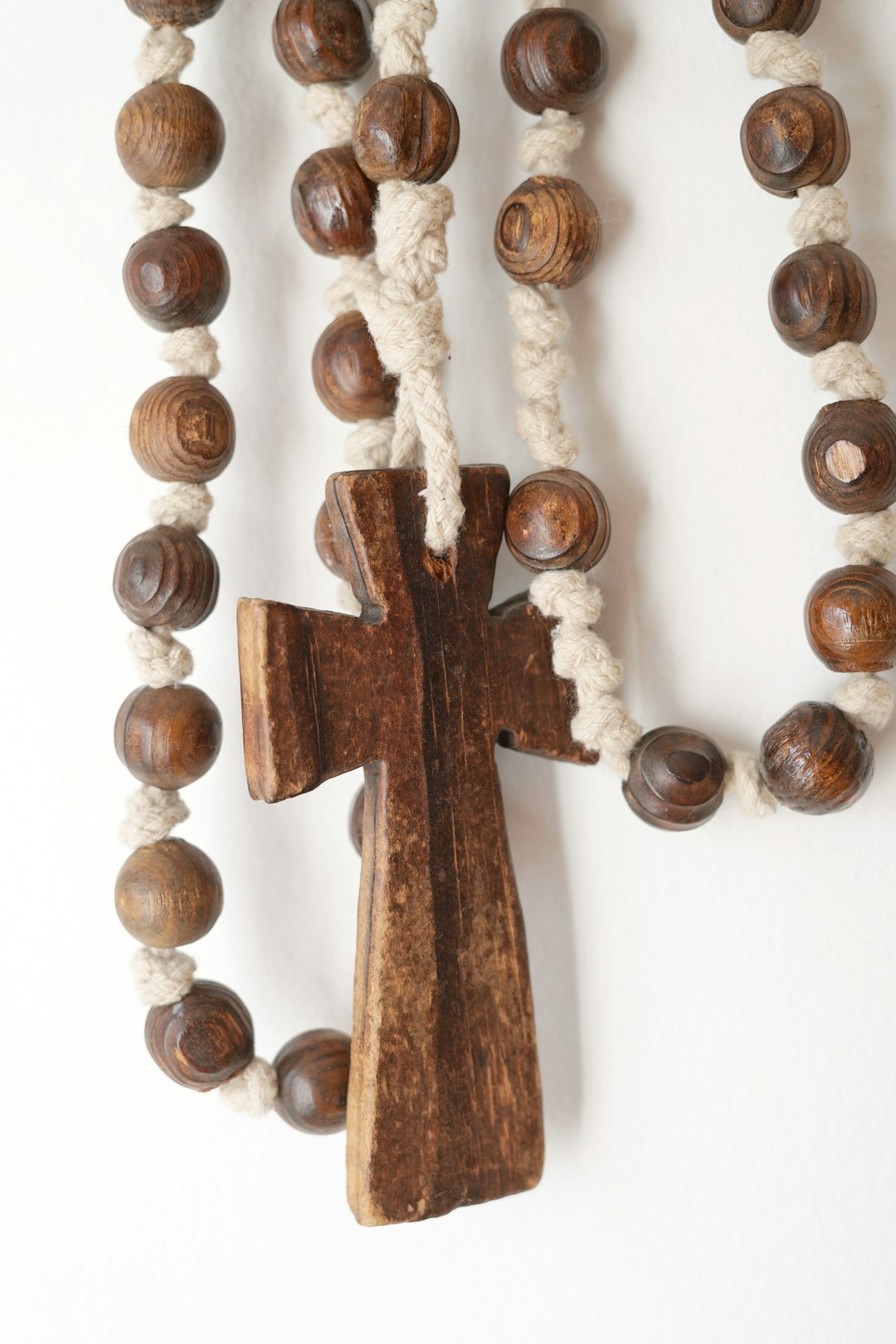 services-01 a-wooden-cross-hanging-from-a-white-wall-mv7fqlzox30